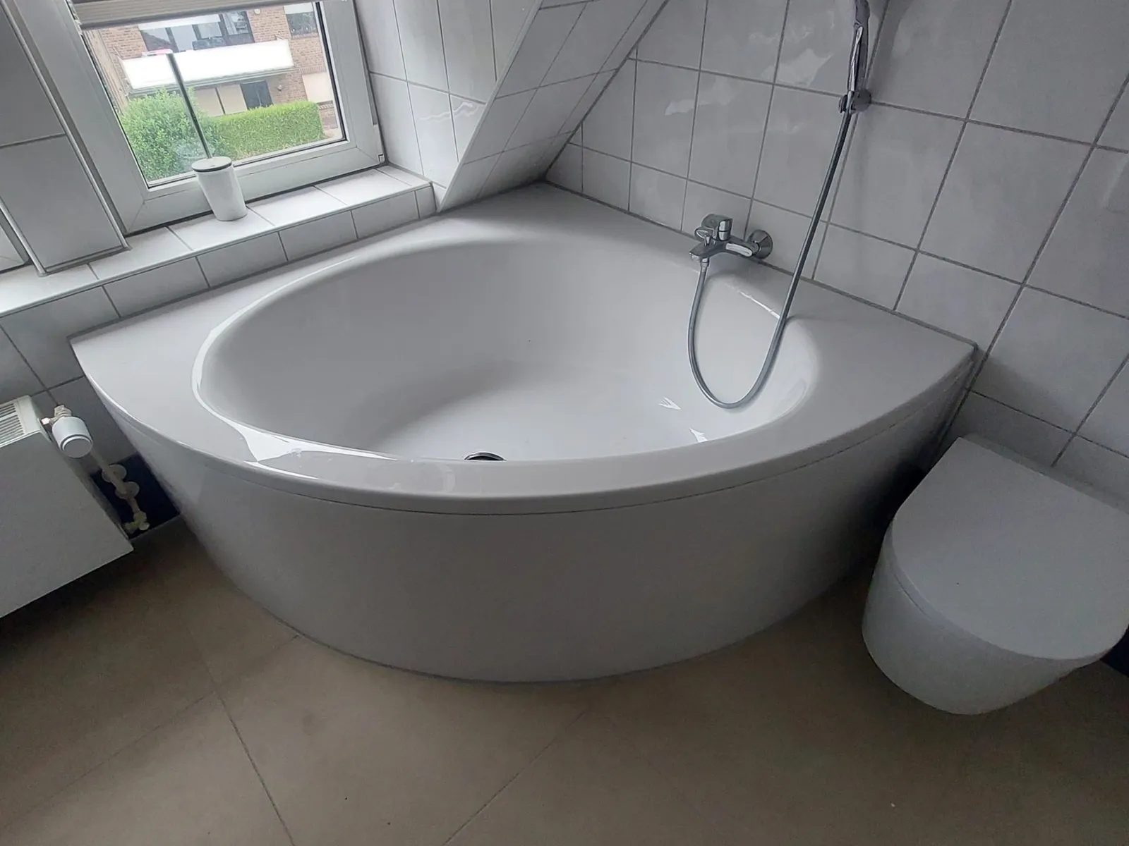 Fertig saniertes Badezimmer mit Eckbadewanne und neuen Fliesen