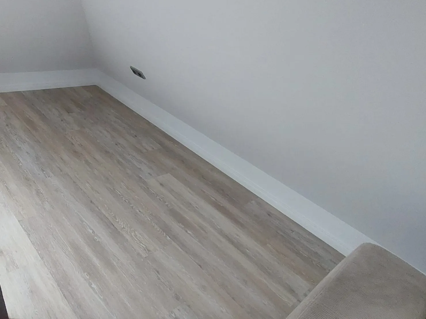 Dachzimmer mit neuem Boden in Holzoptik und frisch gestrichenen Wänden