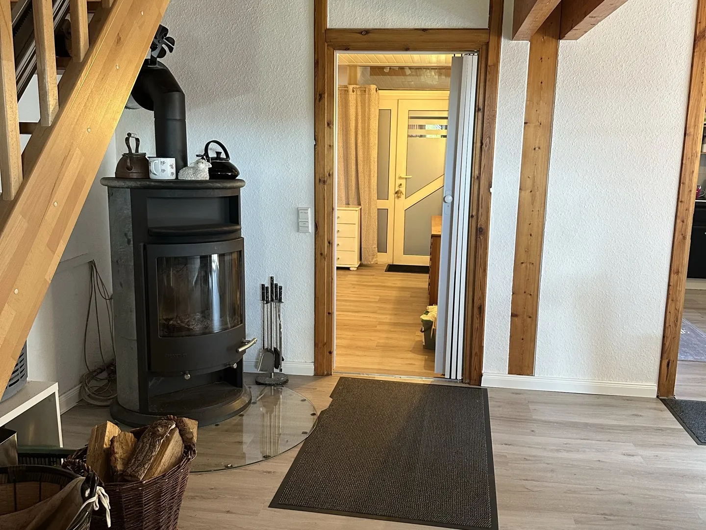 Wohnbereich mit Kaminofen und neuem Boden, Blick in den Flur