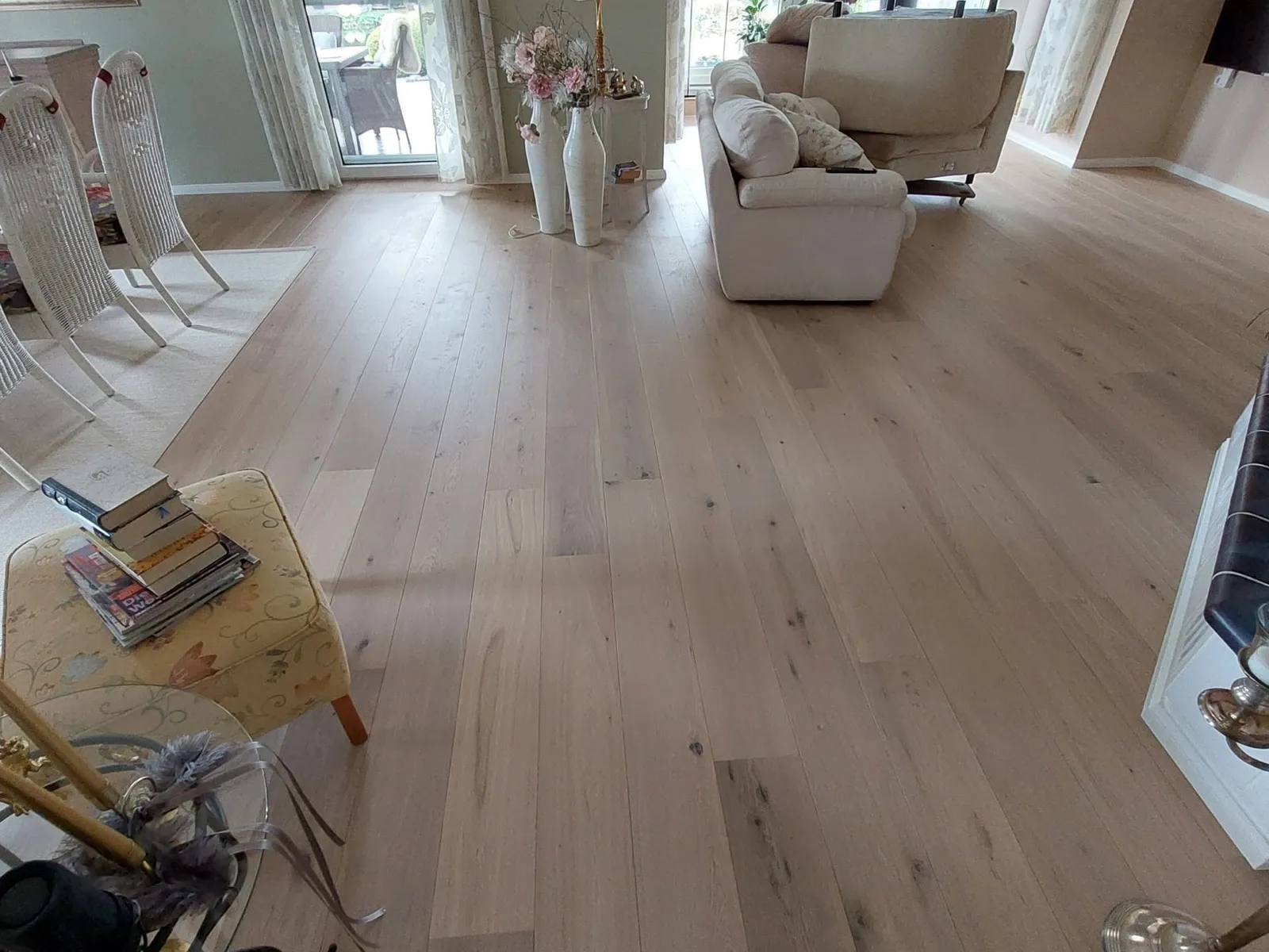 Wohnzimmer nach der Sanierung mit neu verlegtem hellem Parkett